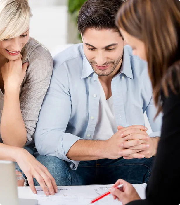 A couple reviewing financial documents with an advisor during a personal finance consultation