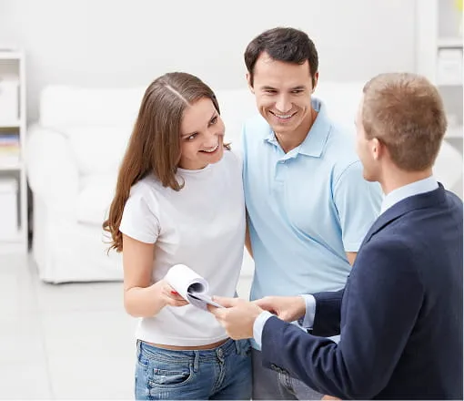 Couple reviewing mortgage documents with a home loan advisor in a bright office setting
